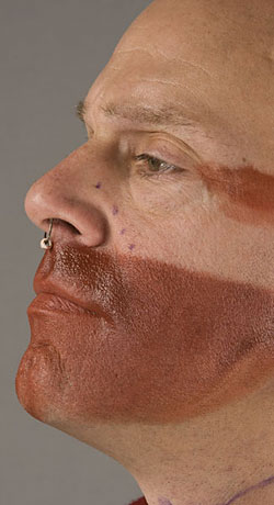 close up of model's face showing red paint on lower face