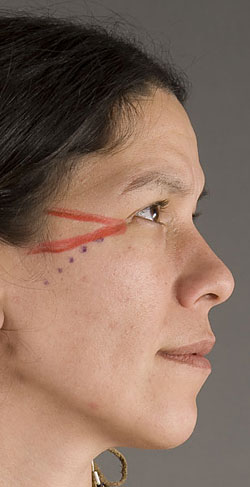 close up of model's face showing red paint near eyes