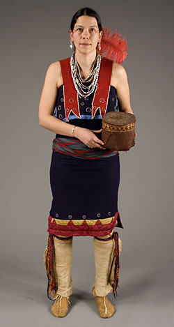 model wearing blue and red dress, leather leggings, moccasins and holding basket