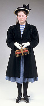 girl wearing black straw boater, black knee length coat, white gloves and holding schoolbooks bound with a strap