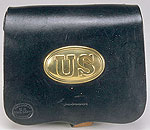 close up of closed black leather cartridge box with decorative brass oval on front that says US