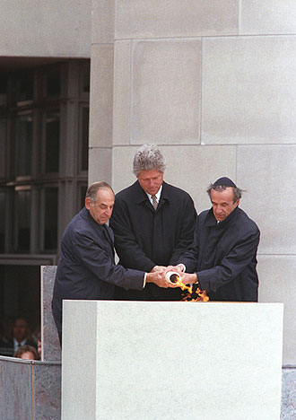 file:/activities/oralhistory/cappics/cohen1945a_flame, alt: President Clinton, Elie Wiesel, and Harvey Meyerhoff lighting an eternal flame