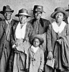 family of african americans in traveling clothes